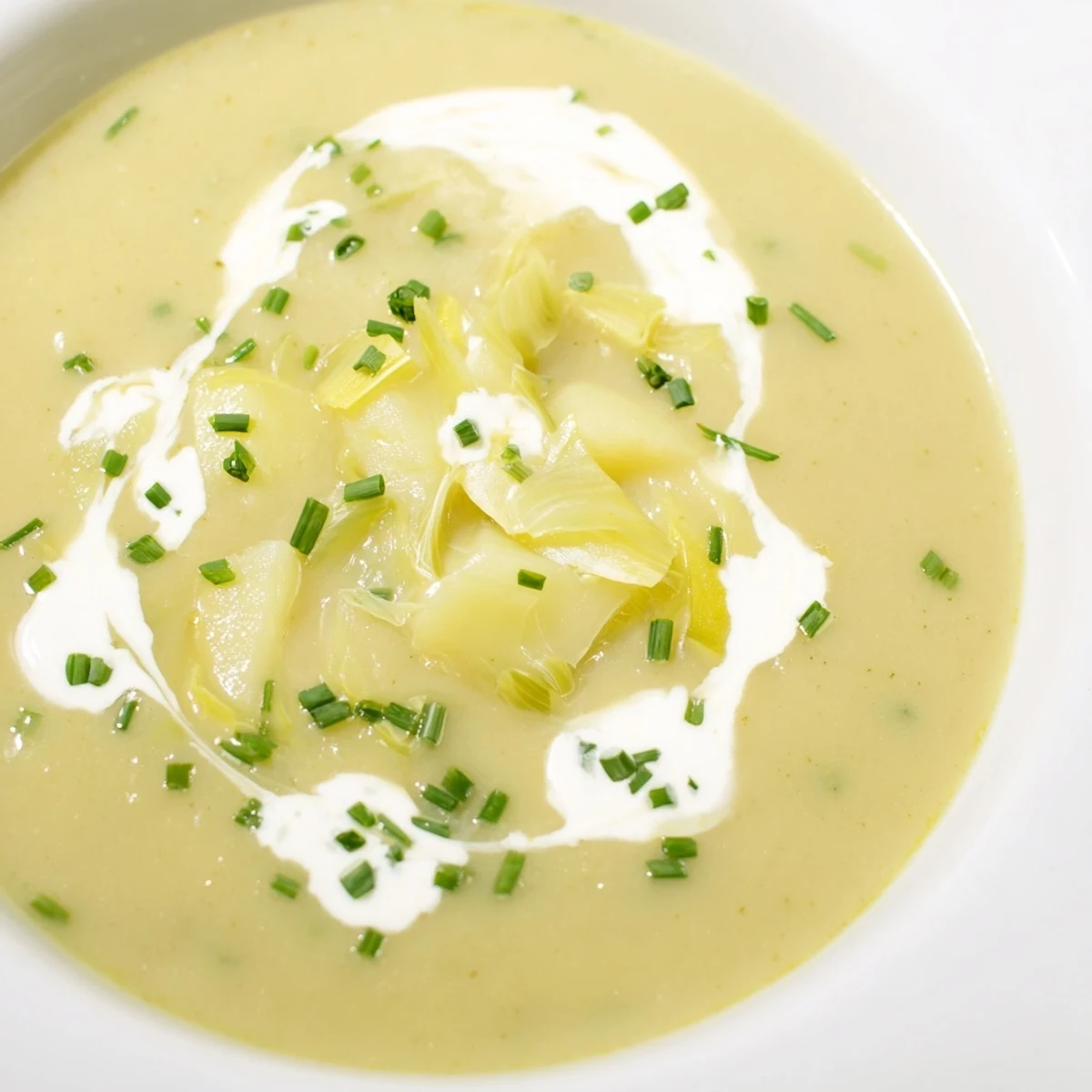 Creamy Leek and Potato Soup garnished with fresh chives in a rustic bowl.