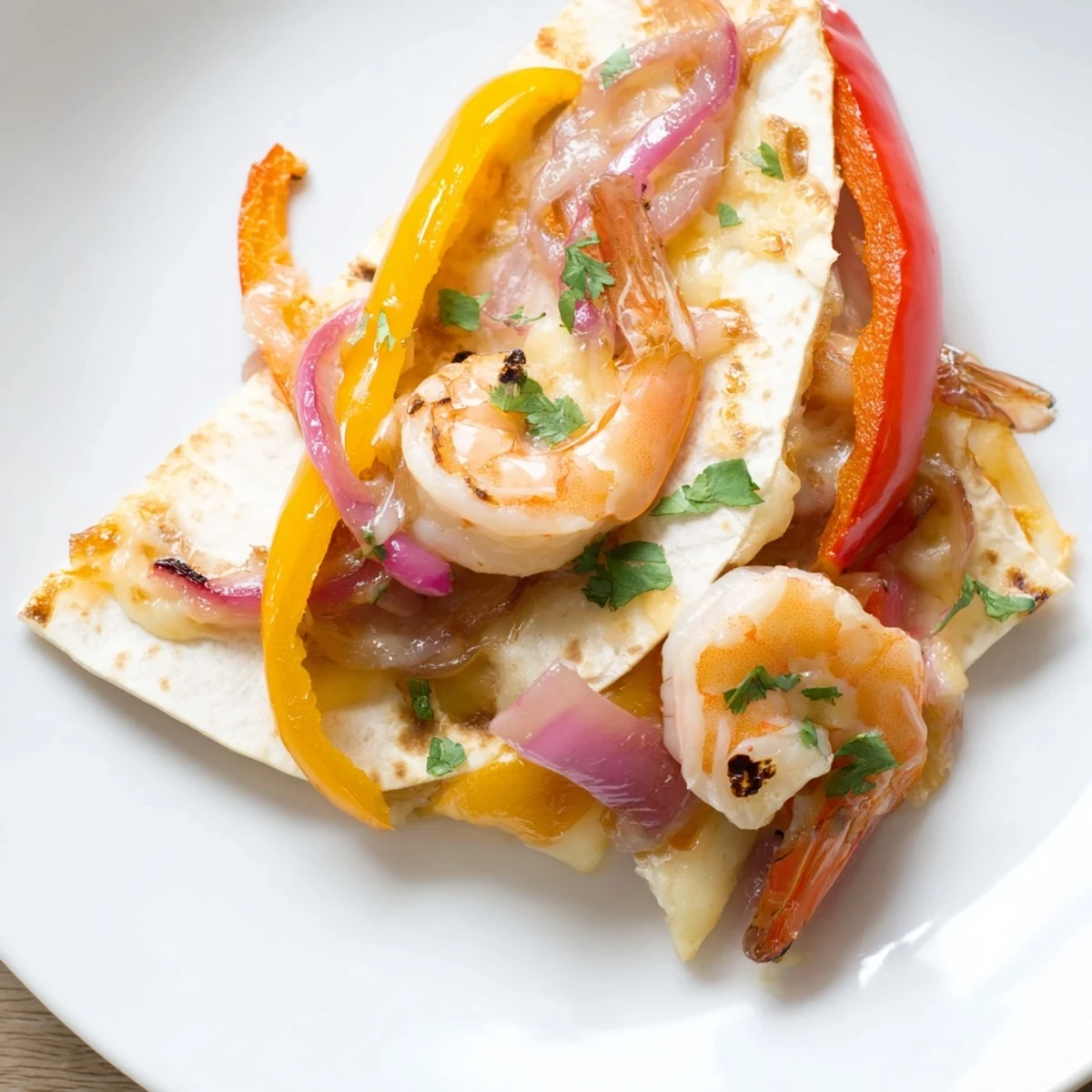 Golden-baked Shrimp Fajita Sheet Pan Quesadillas rest on a platter with melted cheese and colorful peppers spilling from the crispy tortillas.  
