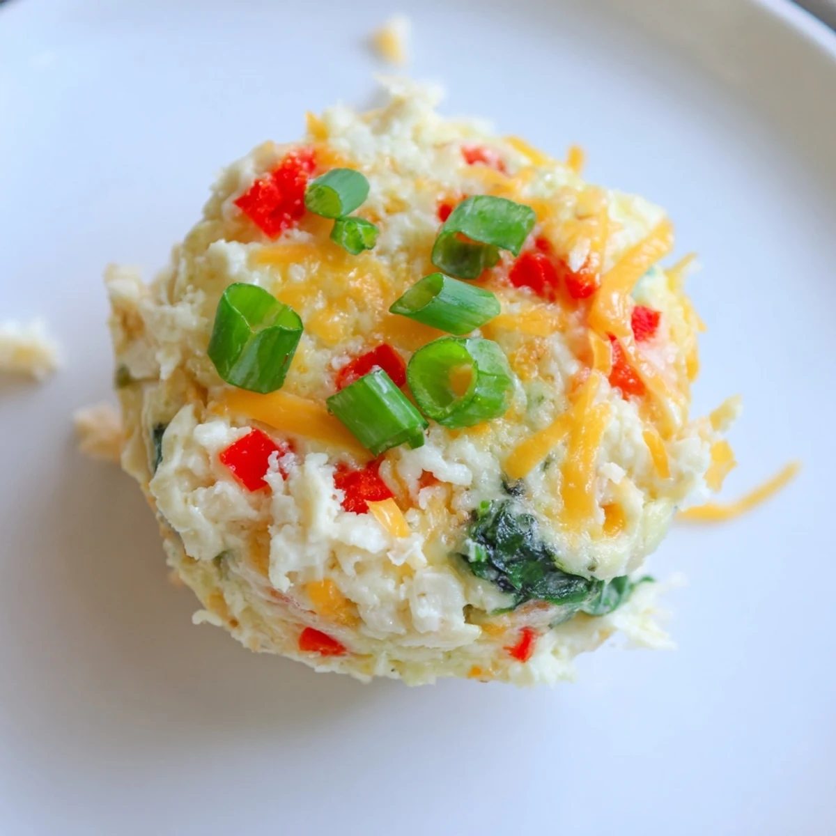 Golden-brown Cottage Cheese Egg Bites sit in a muffin tin with melted cheddar and parmesan on top.  