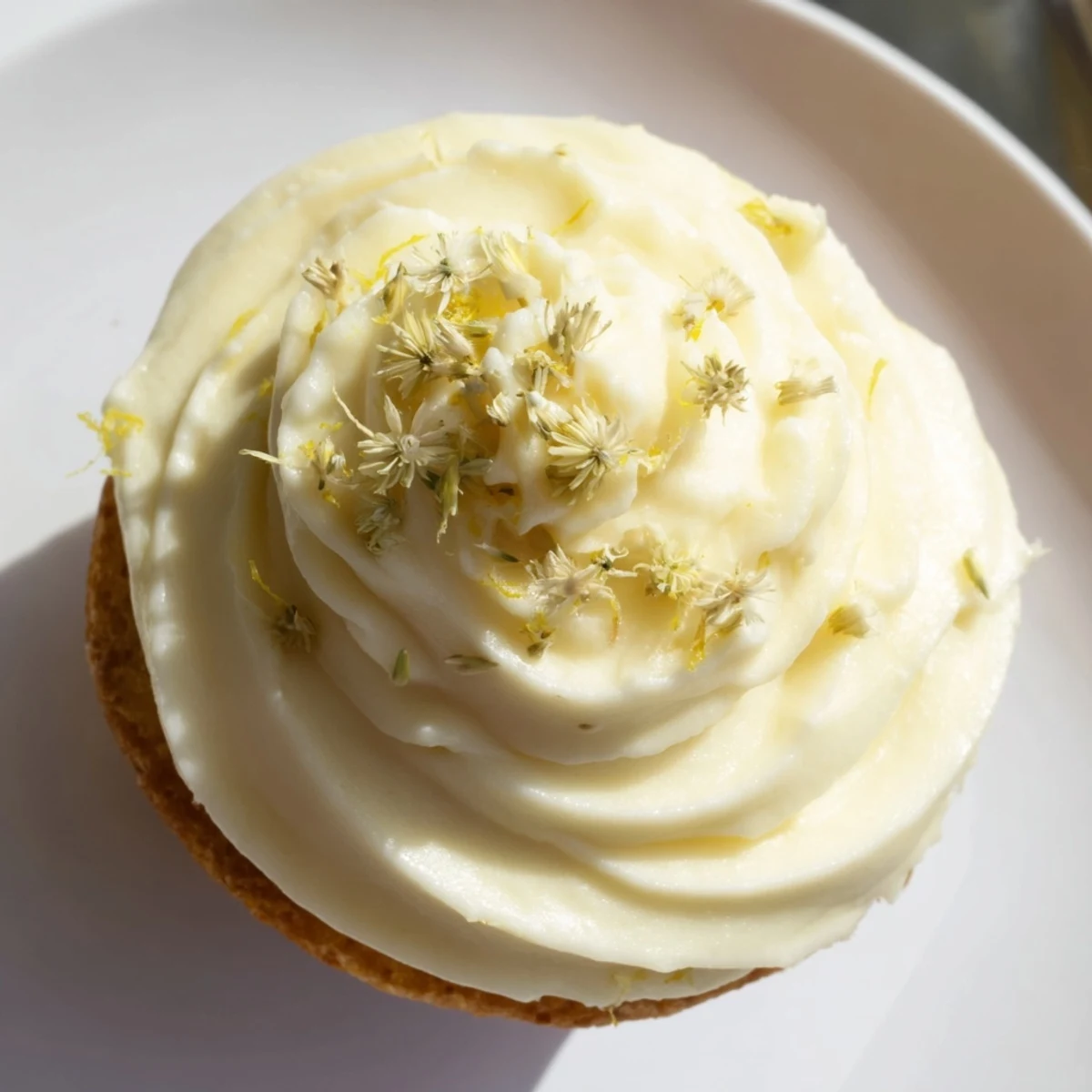 Delicate Elderflower Cupcakes sit on a cooling rack, brushed with syrup and topped with floral buttercream swirls.