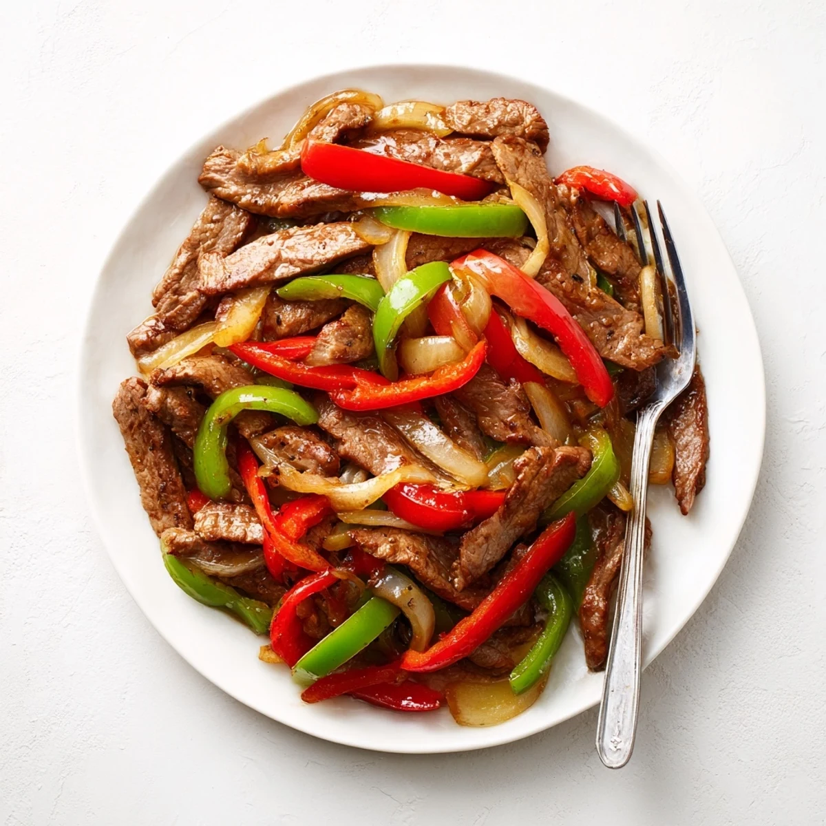Sizzling Chinese Pepper Steak With Onions served hot over white rice for a weeknight dinner.