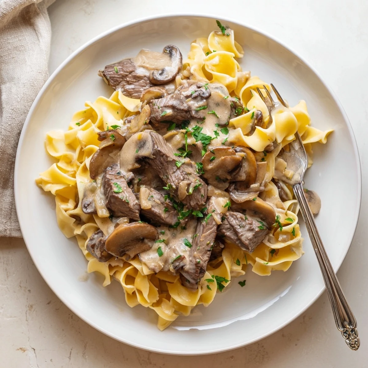 Tender beef strips in rich sour cream sauce with sliced mushrooms over wide egg noodles