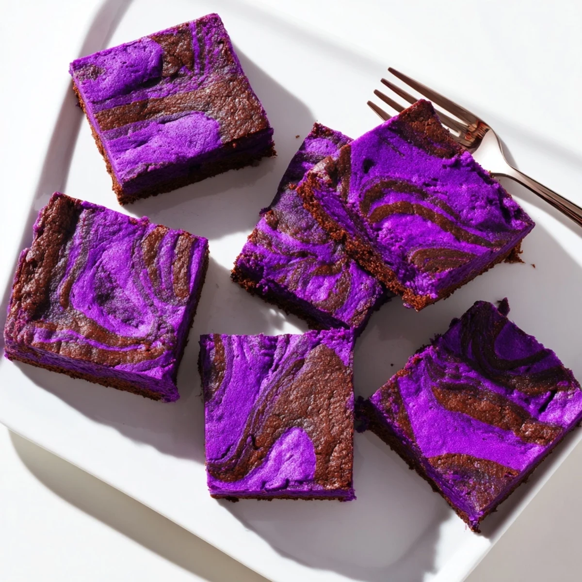 Sliced ube brownies showcasing vibrant purple crumb and glossy chocolate marbled topping