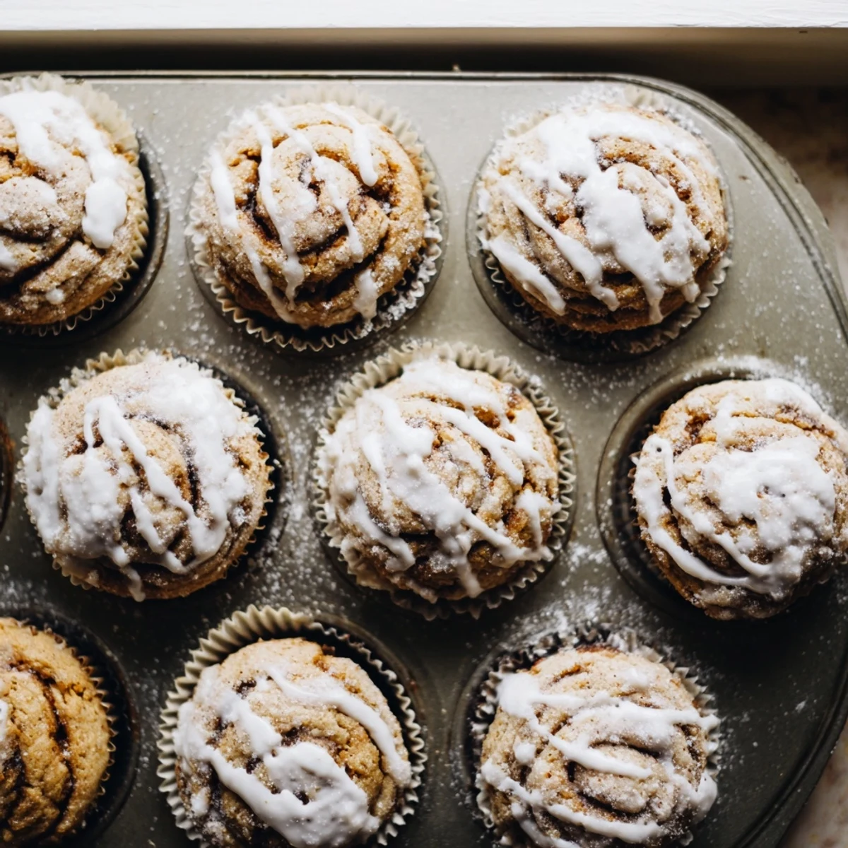 Fluffy high protein muffins drizzled with white icing and warm cinnamon ribbons