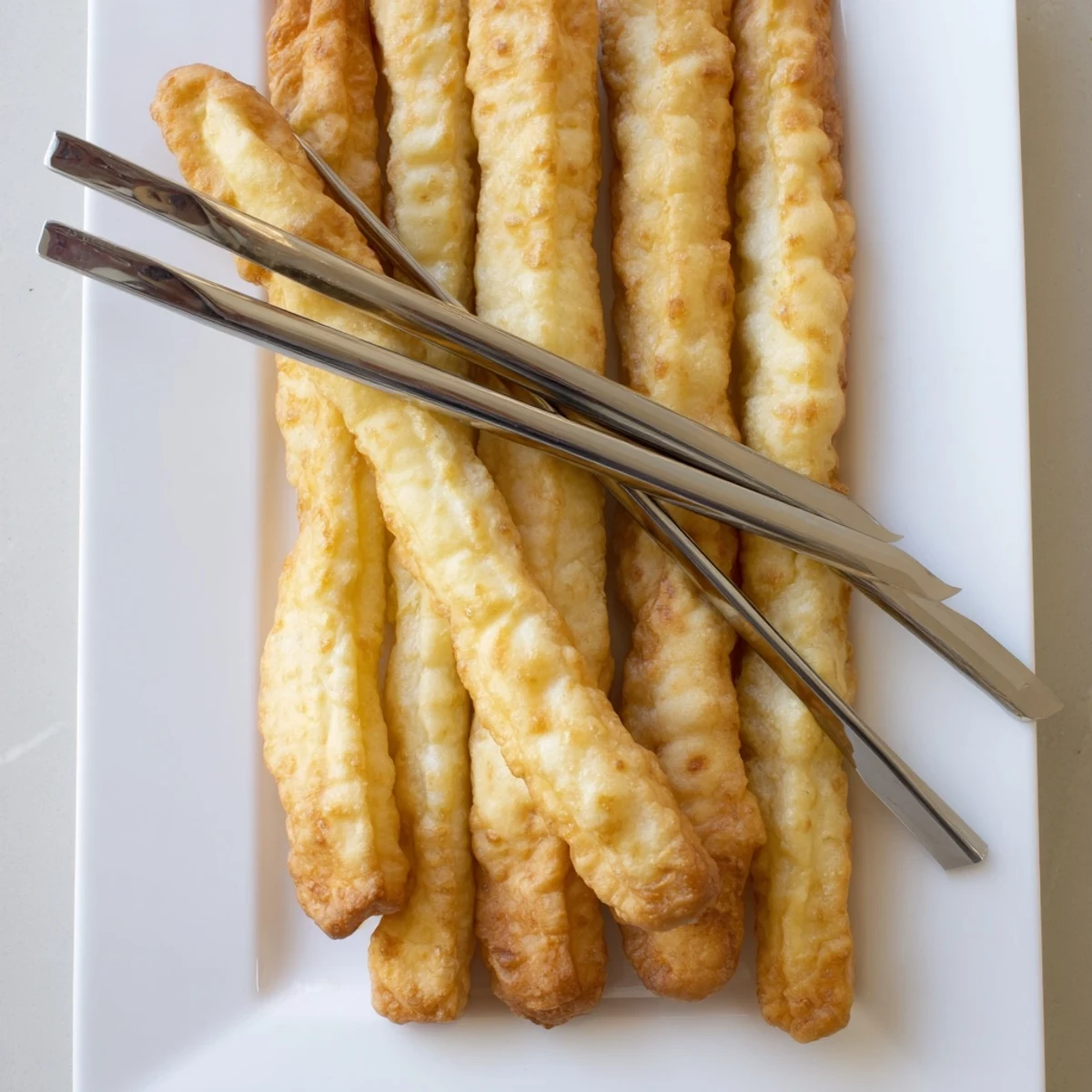 Traditional Chinese breakfast Youtiao fried sticks served warm alongside steaming soy milk for dipping