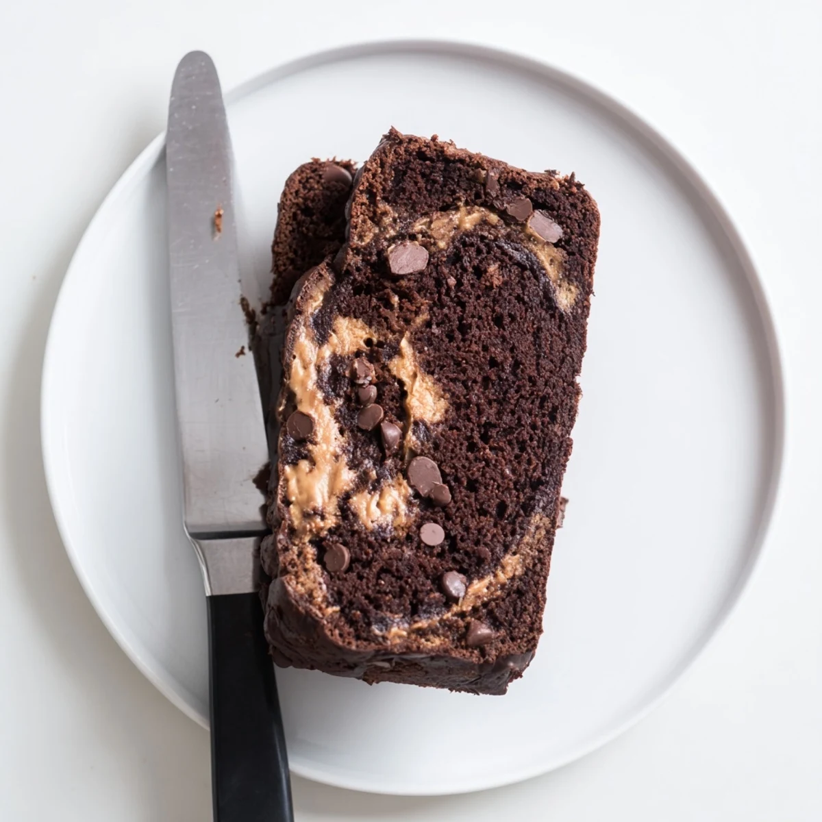 Thick slice of chocolate peanut butter banana bread showing moist dark crumb and melted chocolate chunks