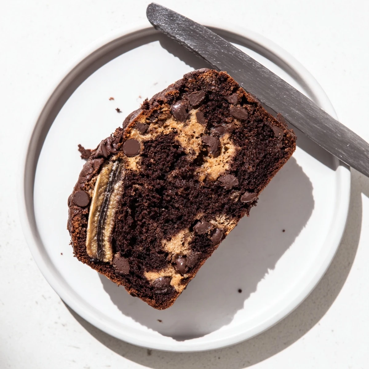 Warm freshly baked chocolate peanut butter banana bread cooling on wire rack with peanut butter marbled top