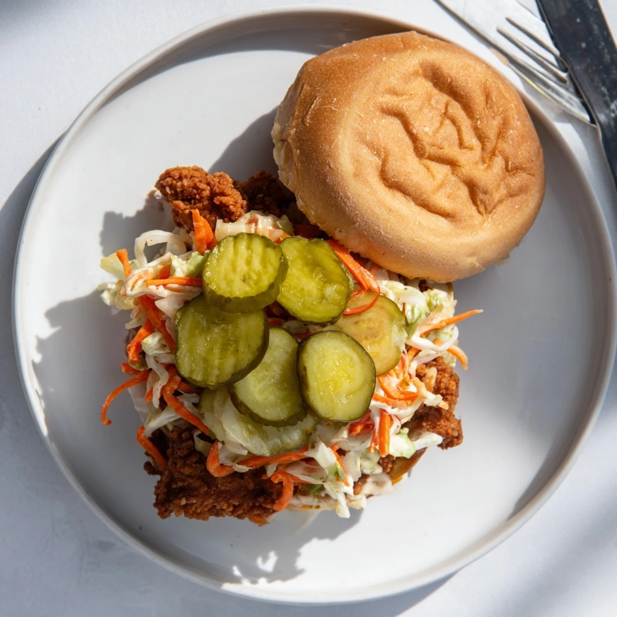 Juicy buttermilk fried chicken thigh sandwich with crunchy cabbage slaw on soft bun