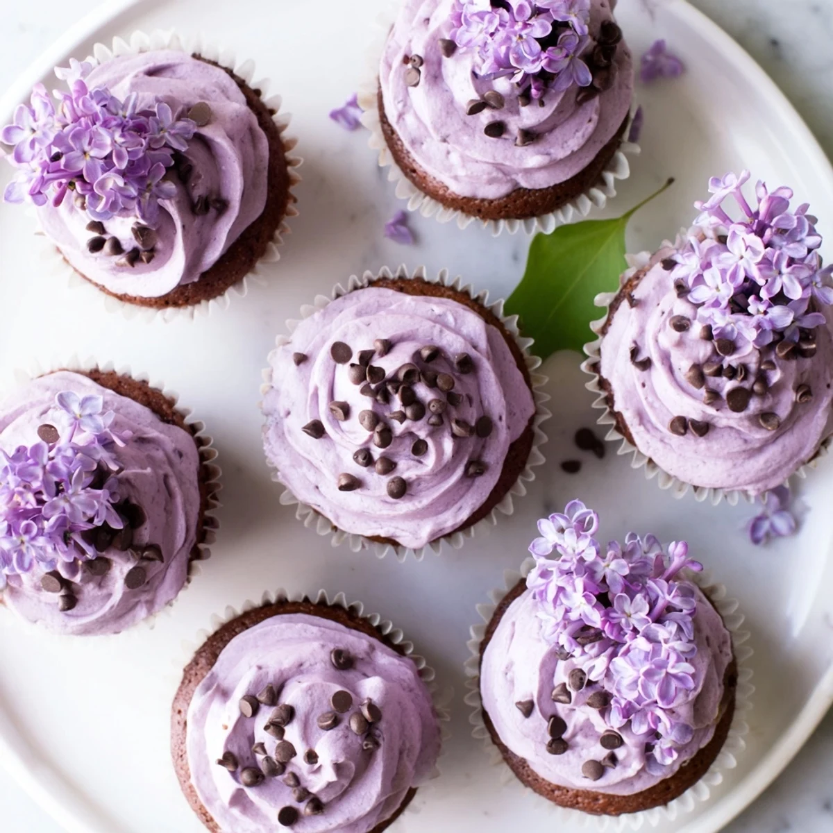 Small batch lilac chocolate cupcakes topped with lilac buttercream and fresh edible blossoms