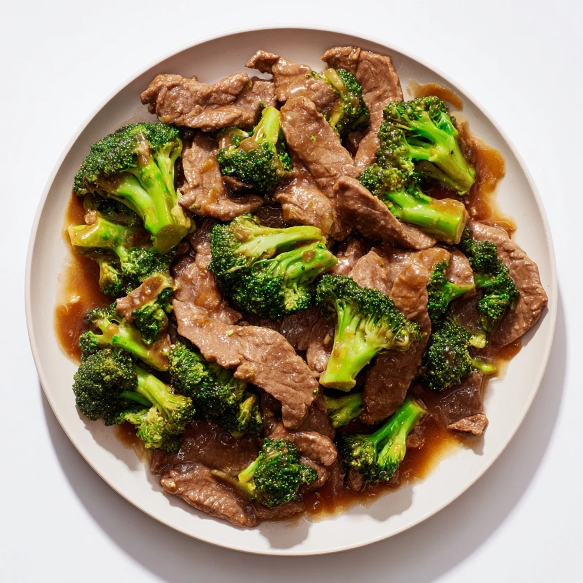Dark glossy sauce drizzled over sizzling beef and crisp broccoli florets in a hot wok