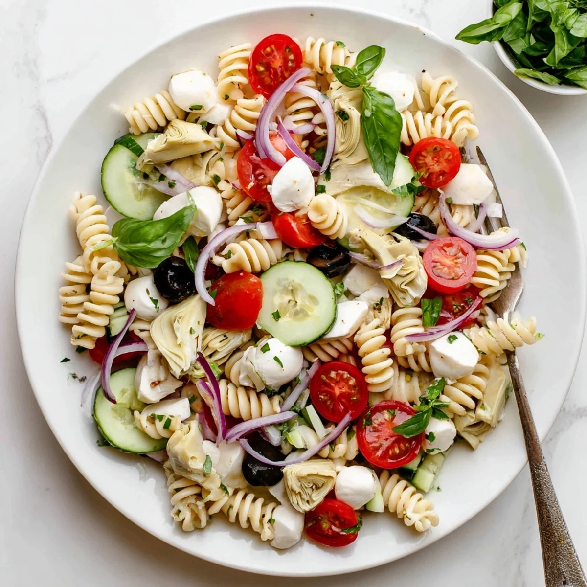 Colorful Italian vegetarian pasta salad with cherry tomatoes, mozzarella, and fresh basil in a serving bowl