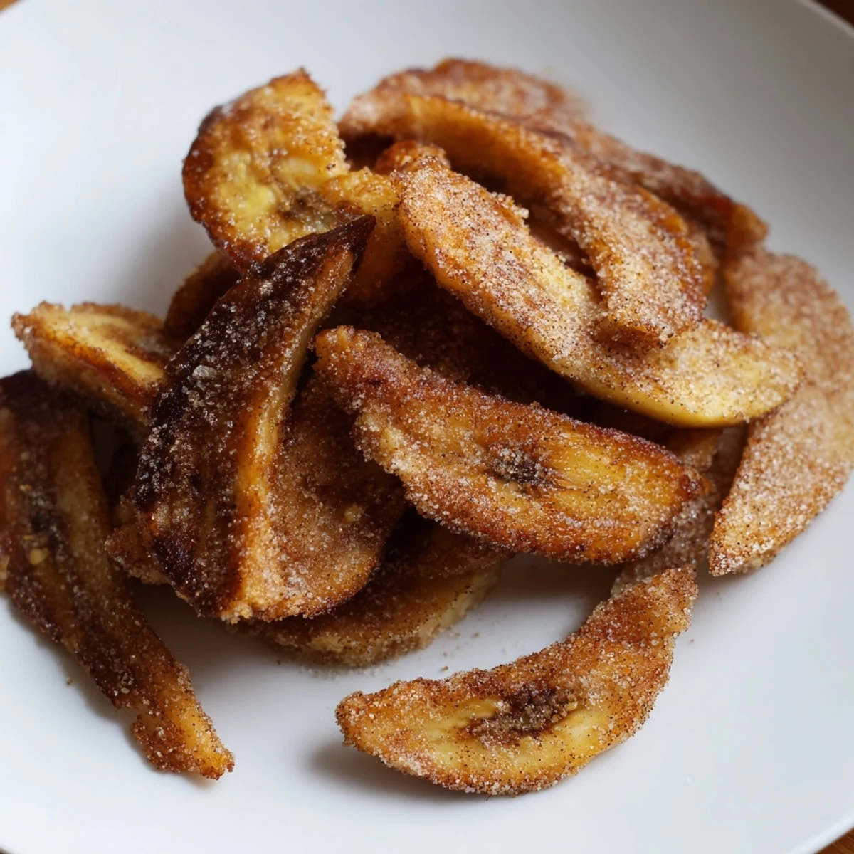 Stack of homemade cinnamon sugar air fryer banana chips with visible sugar speckles