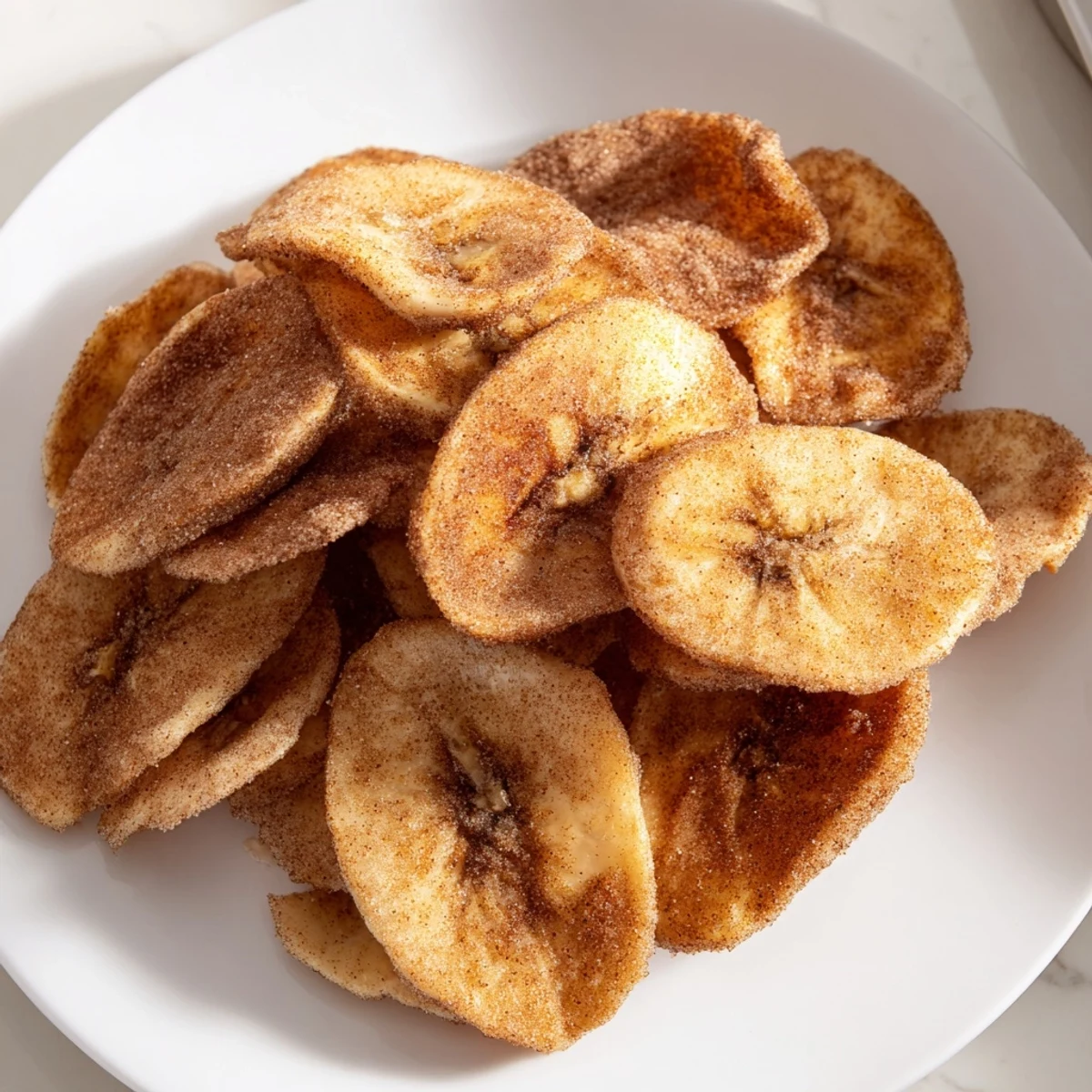 Close up of crispy banana chips coated in sweet cinnamon sugar from air fryer