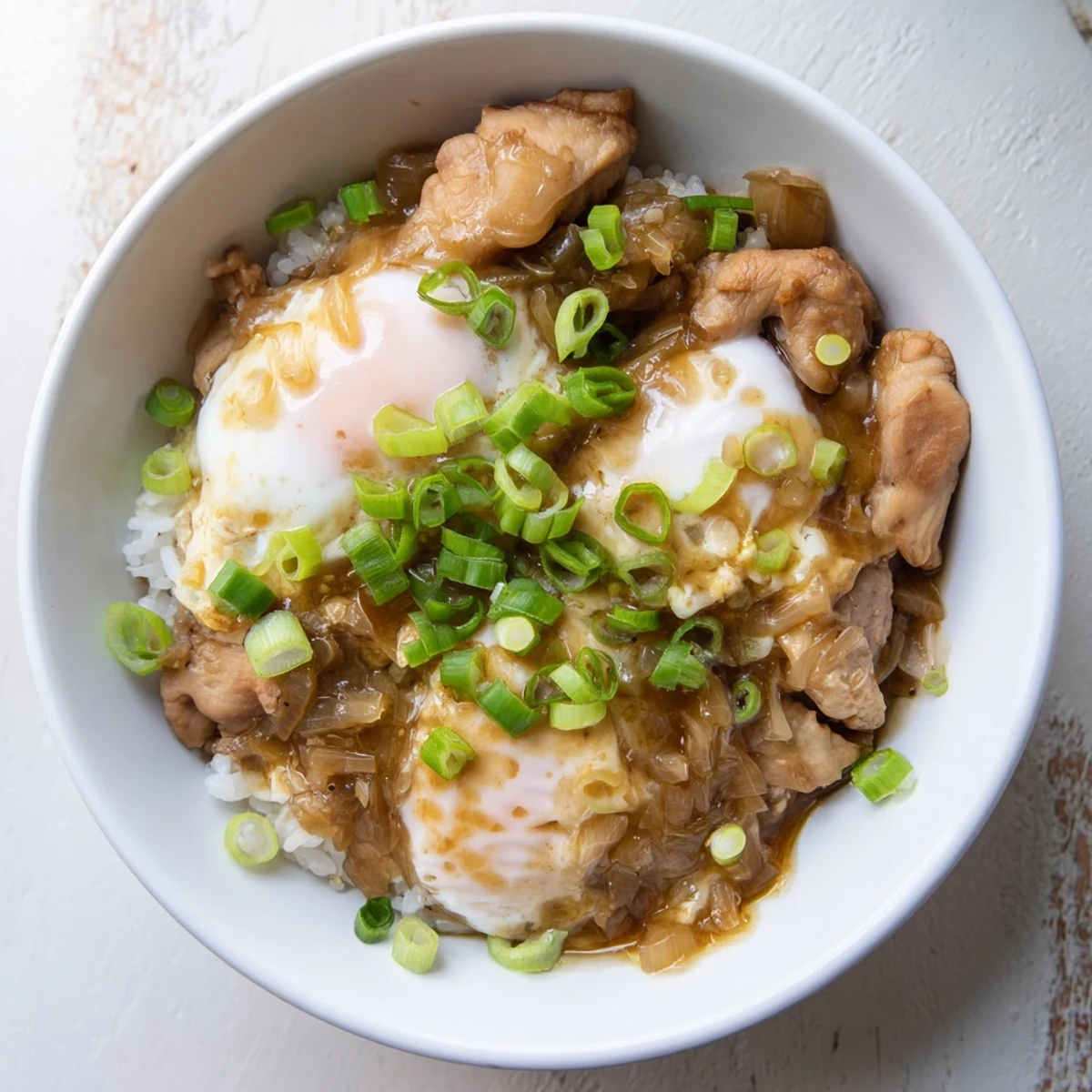 Golden Oyakodon bowl featuring fluffy eggs and tender chicken over steaming white rice