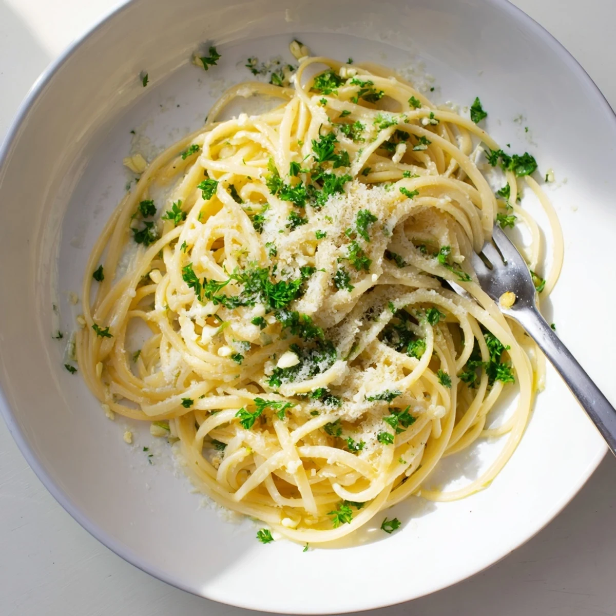 Creamy one pot garlic butter pasta coated in golden parmesan sauce with fresh parsley garnish