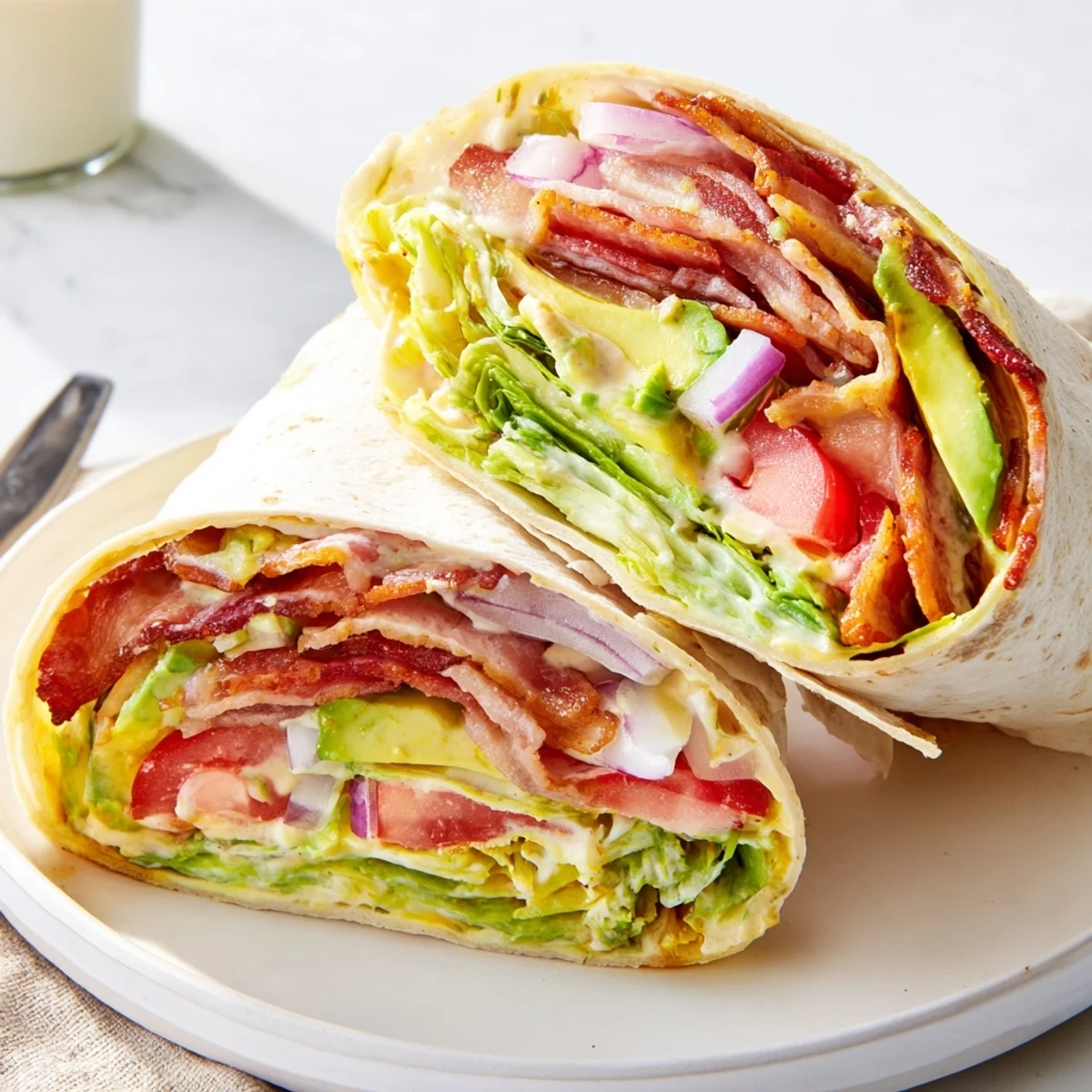 Chilled Meal Prep BLT Wraps sliced in half, showing crunchy lettuce and avocado