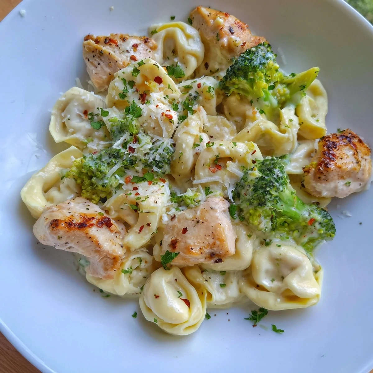 Warm Creamy Garlic Parmesan Tortellini Chicken Broccoli Recipe tossed with bright parsley and rising steam