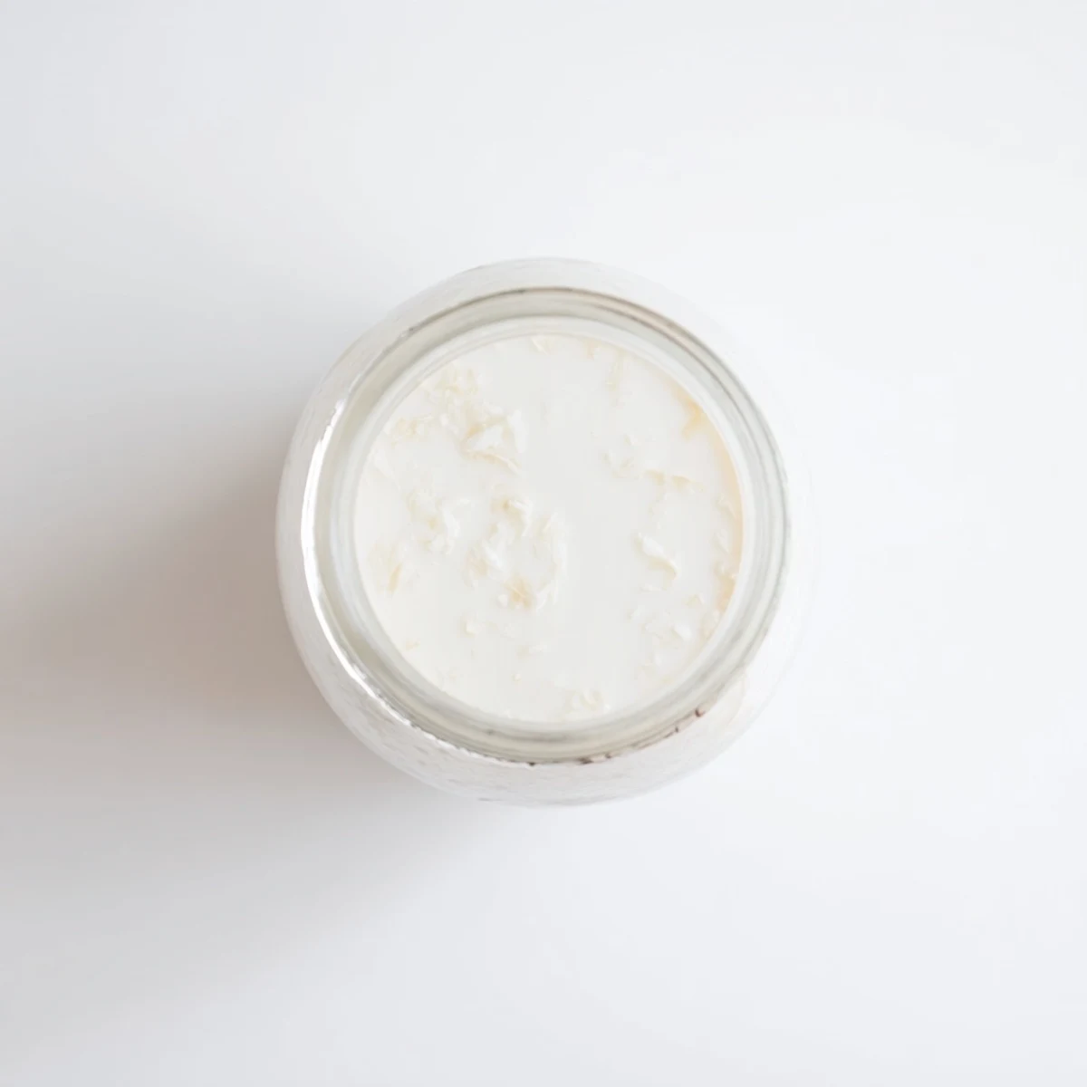 Glass jar filled with creamy white homemade coconut milk, perfect for plant-based recipes