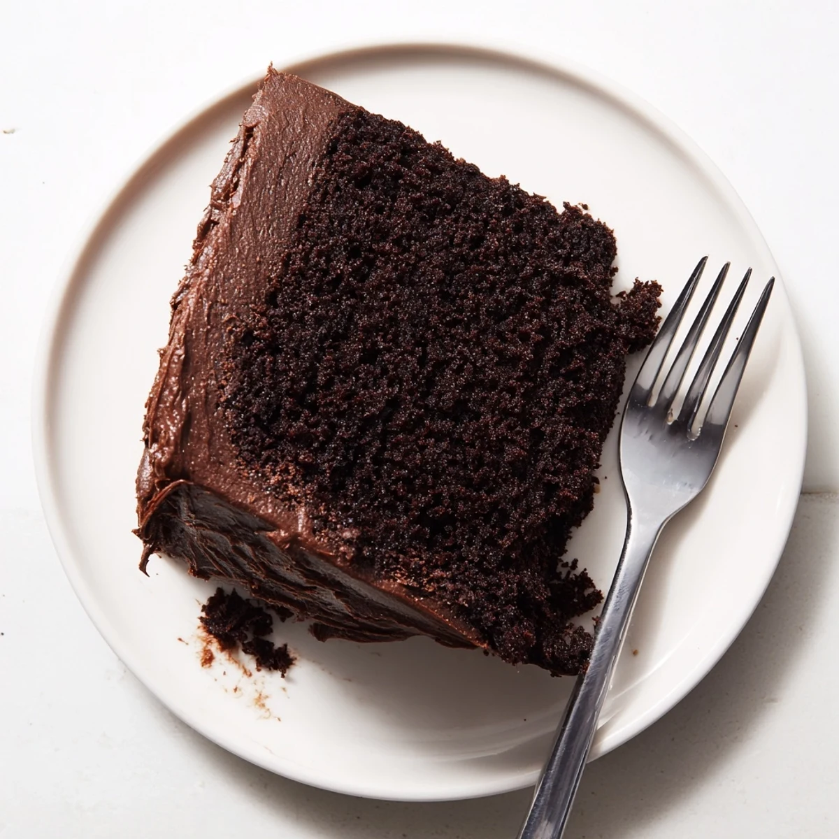 Rich chocolate mayonnaise cake with moist tender crumb and glossy chocolate frosting on a serving plate