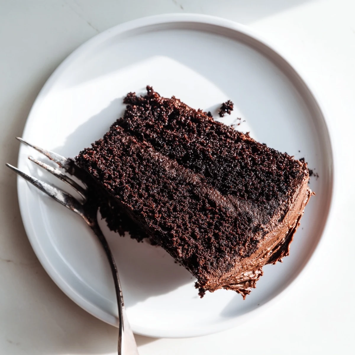 Decadent slice of chocolate cake made with mayonnaise revealing incredibly soft texture and dark cocoa layers