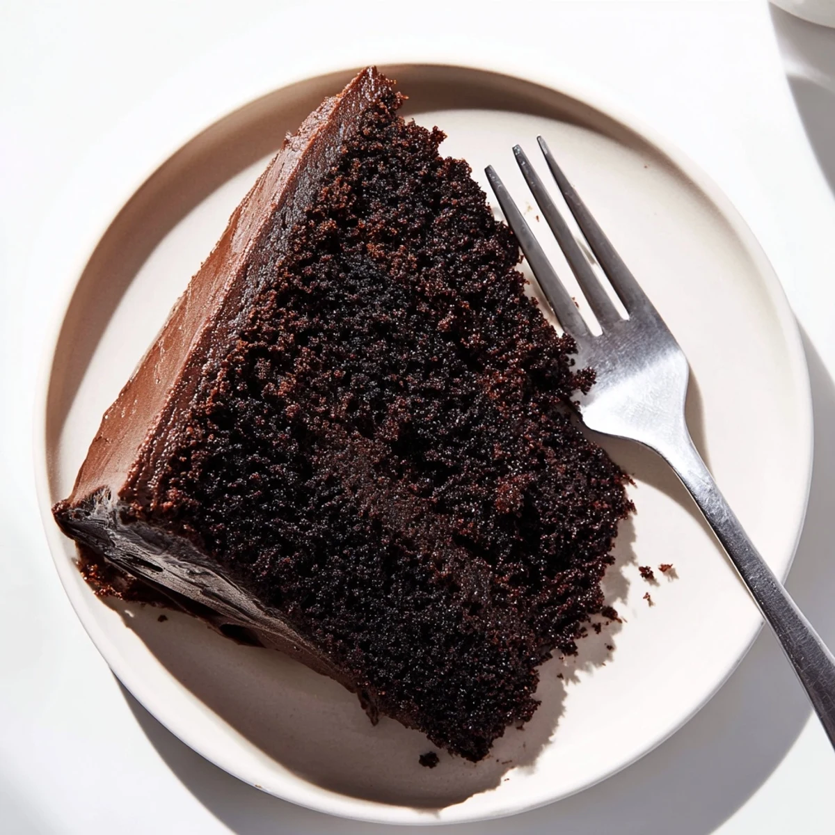 Homemade chocolate mayonnaise cake showing tall dark slices with fluffy interior topped with creamy frosting swirls