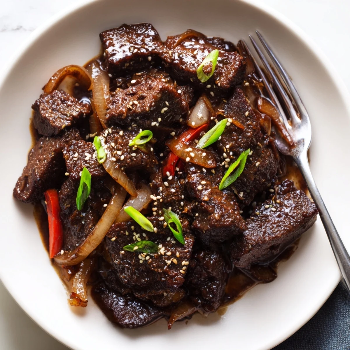 Golden seared Asian-inspired cube steak topped with green onions and toasted sesame seeds