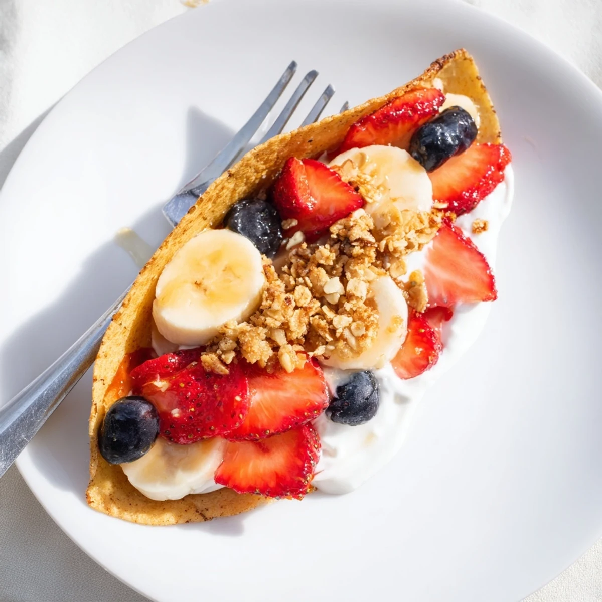 Folded pancake tacos filled with yogurt, berries, and crunchy granola toppings.