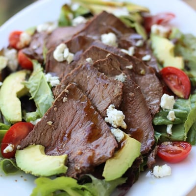 Creamy crumbled Gorgonzola tops this balsamic steak Gorgonzola salad with grilled corn alongside juicy sliced steak