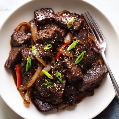 Golden seared Asian-inspired cube steak topped with green onions and toasted sesame seeds